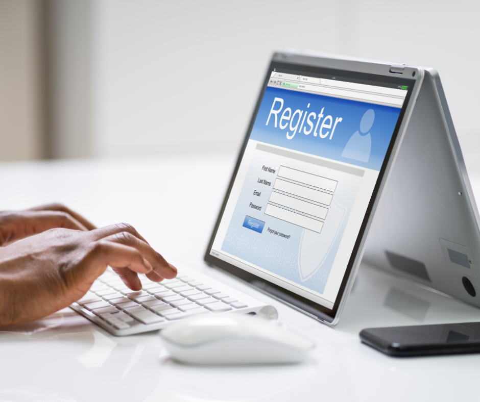 A touchscreen laptop with a wireless keyboard and a wireless mouse. The laptop is displaying a Registration Form. A person is typing.