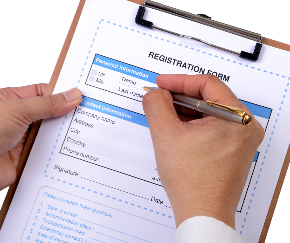 Registration form being filled in by someone on a clipboard.