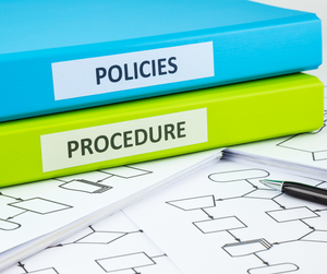 A green and a blue folder marked as policies and procedure.